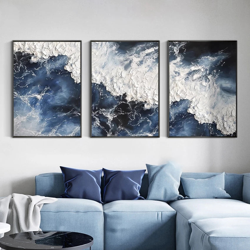 Three abstract wall art pieces above a light blue sofa with matching pillows.