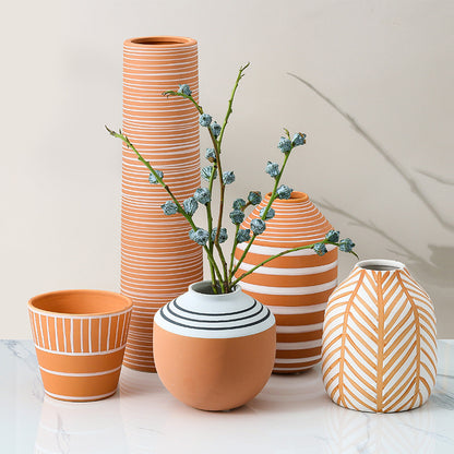 Set of ceramic vases with striped and patterned designs on a light background