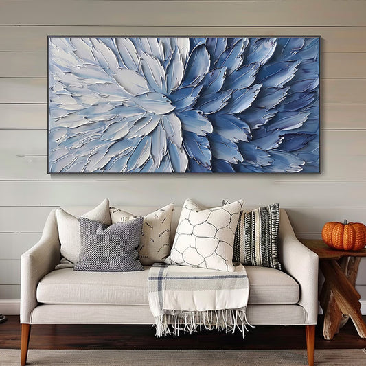 Living room with a large abstract blue and white floral painting above a beige sofa.