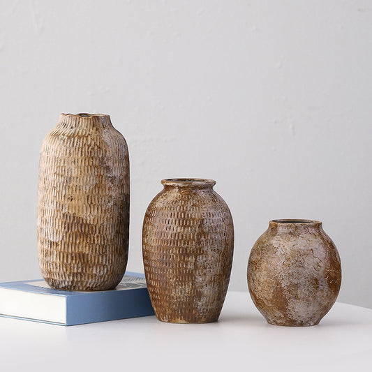 Three textured ceramic vases of different sizes on a light gray background