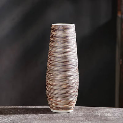 Tall ceramic vase with textured design on a dark background