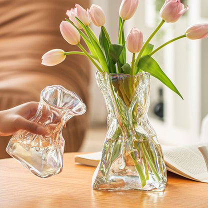 Clear glass vase with pink tulips on a wooden table
