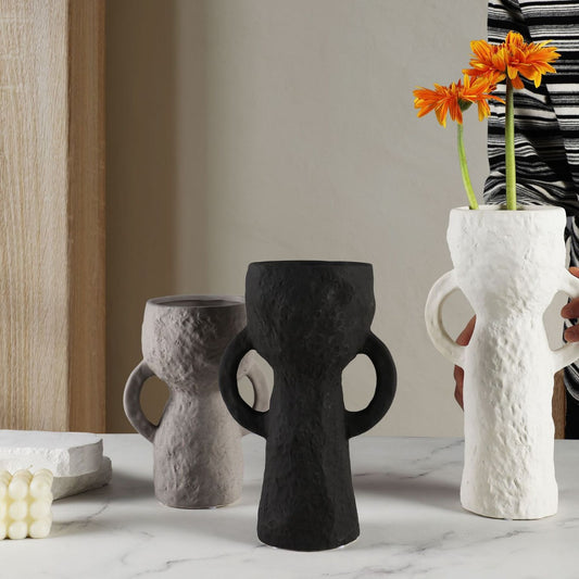 Three unique vases on a marble surface with a neutral background
