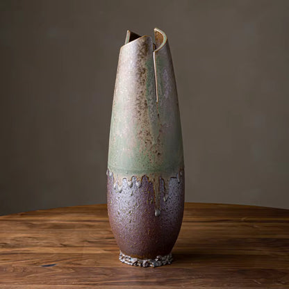 Ceramic vase with unique design on a wooden surface and dark background