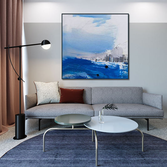Modern living room with a gray sofa, coffee table, and abstract painting on the wall.