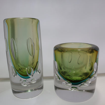Two green glass tumblers on a white background