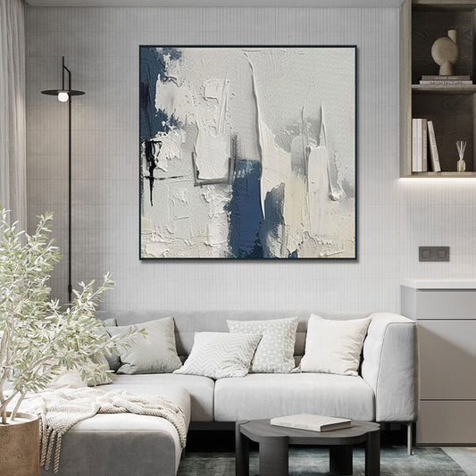 Modern living room with a gray sofa, abstract painting, and decorative items.