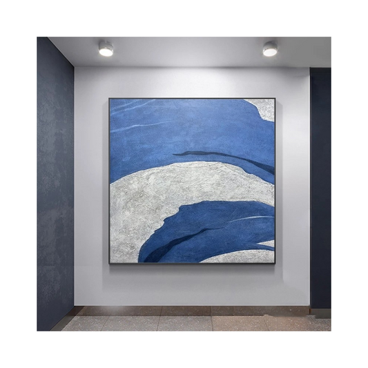 Abstract art piece with blue and white colors on a wall.