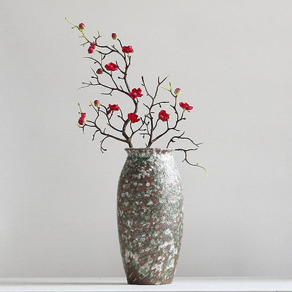 Decorative vase with floral branches on a plain background