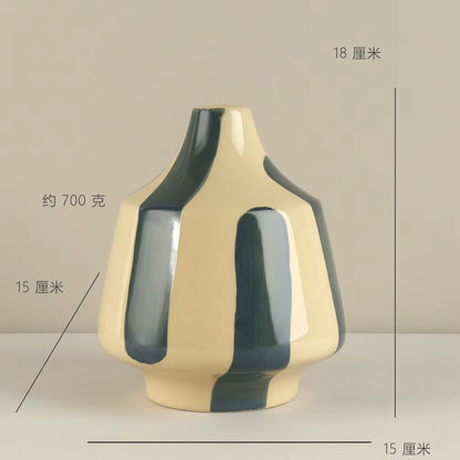Ceramic vase with green and beige design on a neutral background