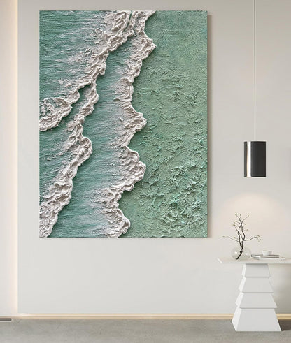 Wall art depicting ocean waves on a textured green background in a modern interior setting.