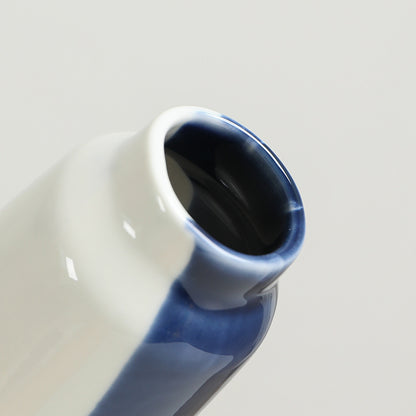 Ceramic vase with blue and white gradient on a light gray background
