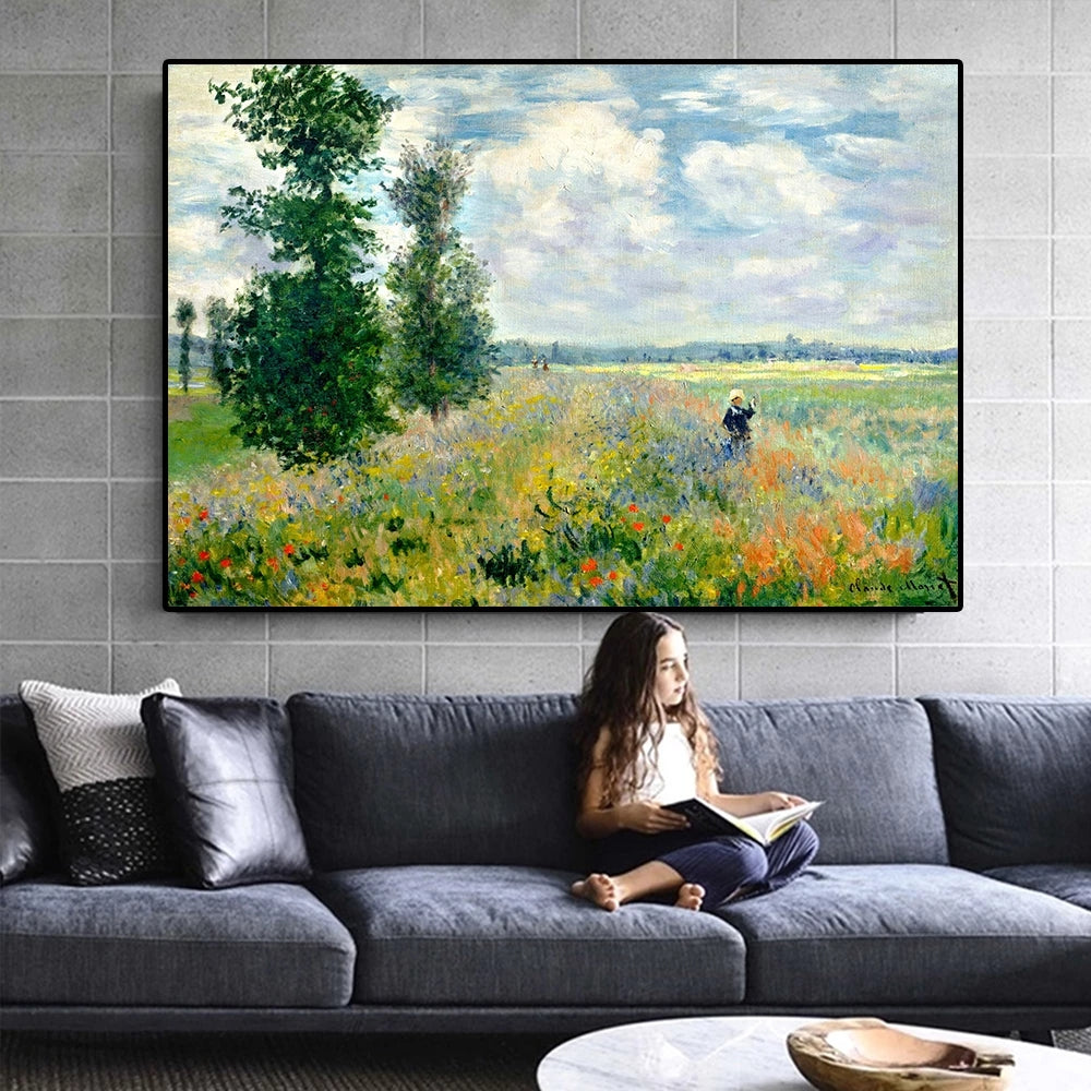 Woman reading a book on a gray sofa with a large framed painting of a landscape above her.