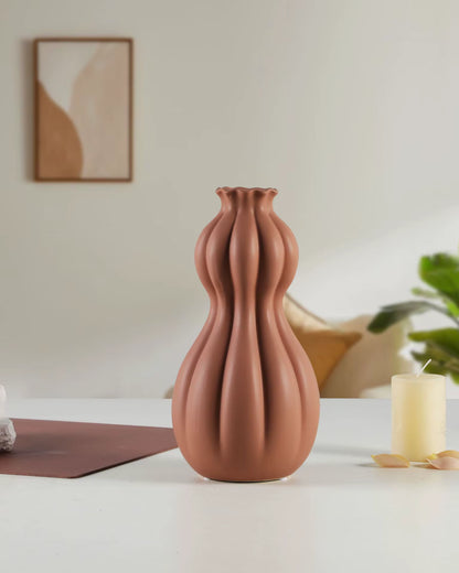 Brown textured vase on a white surface with a blurred background