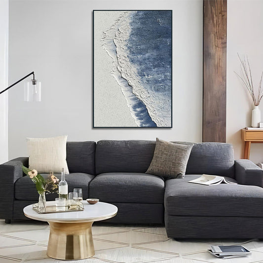 Living room with a gray sectional sofa, coffee table, and beach-themed wall art.