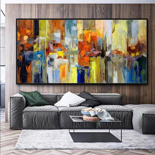Abstract painting in a living room with a gray sectional sofa and coffee table.