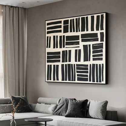 Abstract black and white painting on a wall above a sofa in a living room.