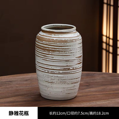 Ceramic vase with striped design on a wooden surface