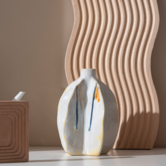White ceramic vase with blue and orange accents on a neutral background