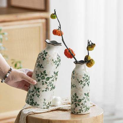 Two ceramic vases with floral patterns on a wooden surface.