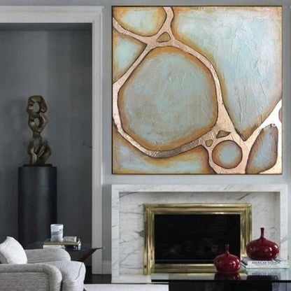 Abstract art piece on a wall above a fireplace in a living room.