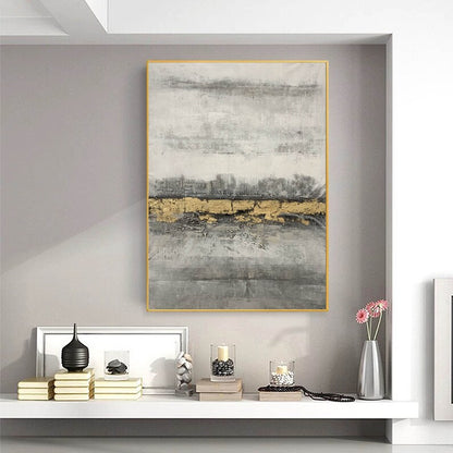 Abstract art piece with gold accents on a gray wall above a shelf with decorative items.