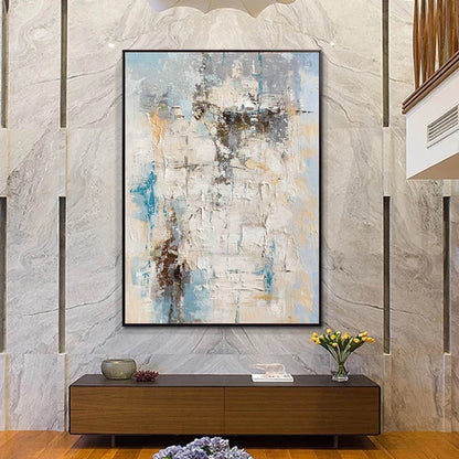 Abstract painting on a wall above a wooden console table with decorative items.