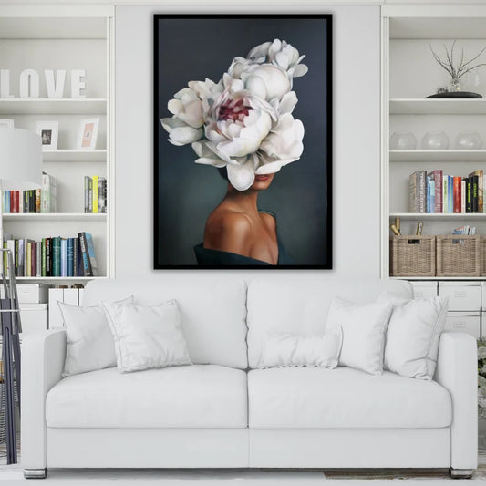 Framed artwork of a woman with flowers on her head above a white sofa in a living room.