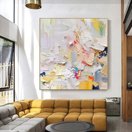 Modern living room with a yellow sectional sofa and abstract art on the wall.