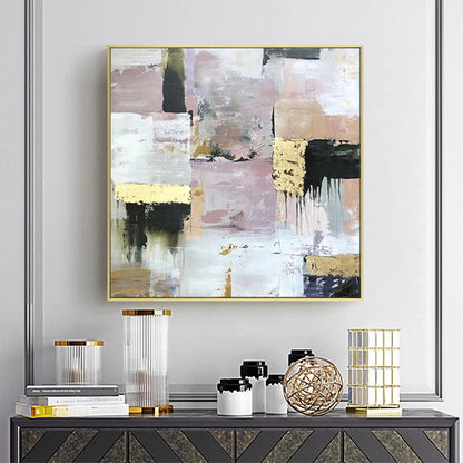 Abstract art piece on a wall above a console table with decorative items.