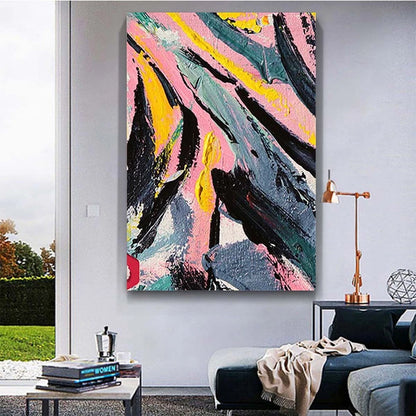 Abstract painting with pink, yellow, and black colors on a wall in a living room.