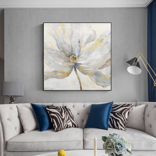 Decorative floral painting above a gray sofa with patterned cushions.